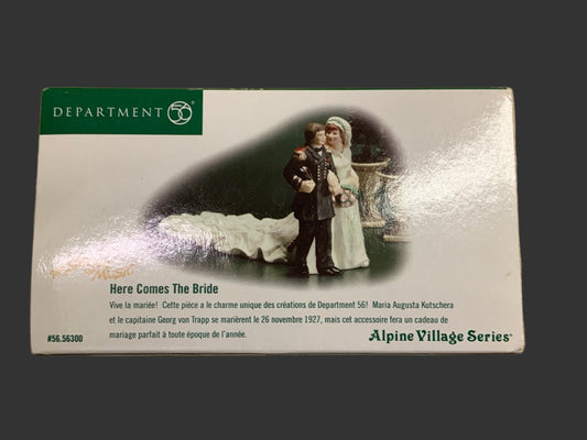Product packaging for 'Here Comes The Bride' from Department 56 Alpine Village Series on a dark background.